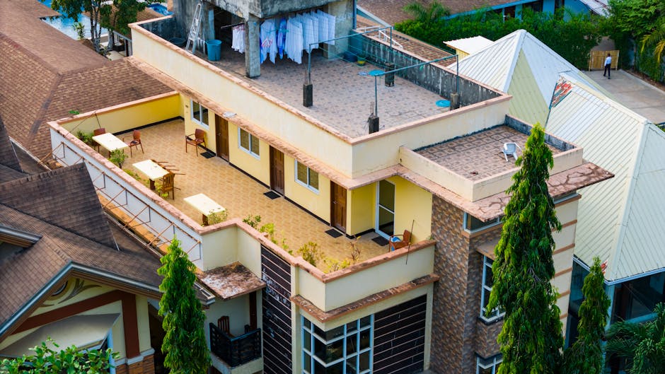 A modern multi-story apartment building with a rooftop terrace and laundry area viewed from above.