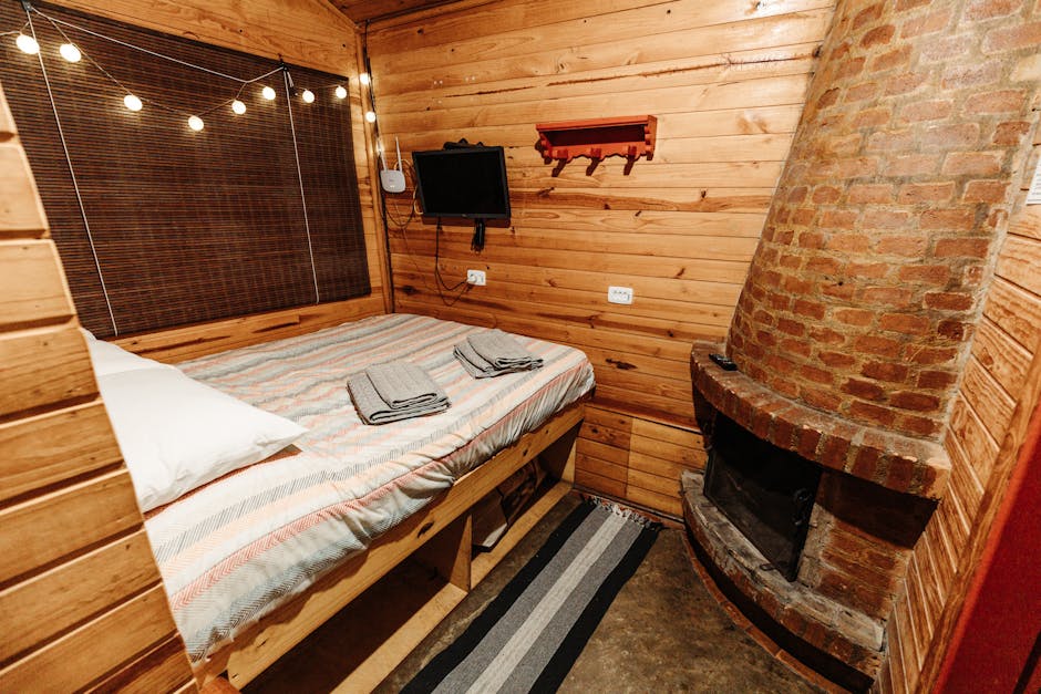 Warm rustic bedroom with wooden walls and a cozy brick fireplace ambiance.