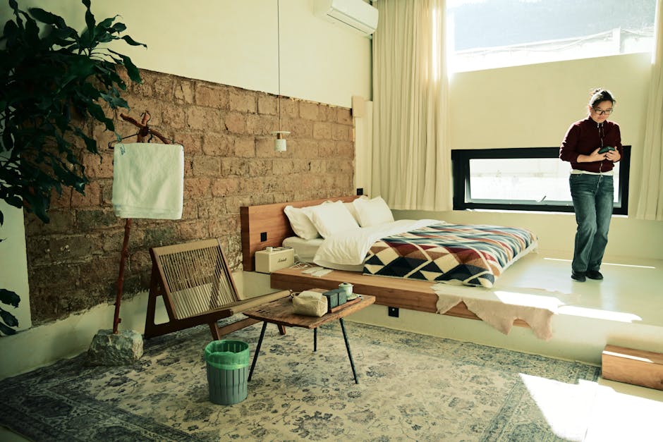 Modern bedroom with a person reading, cozy decor, and natural lighting creating a warm ambiance.