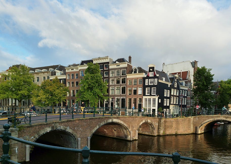 Explore the picturesque canal houses and iconic bridge in Amsterdam's scenic cityscape.